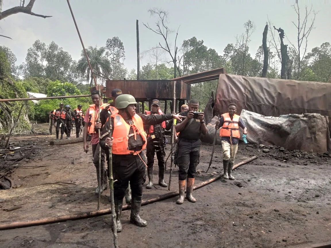 Commander of NNS Pathfinder Commodore Desmond Igbo taking newsmen around illegal refinery in Rivers