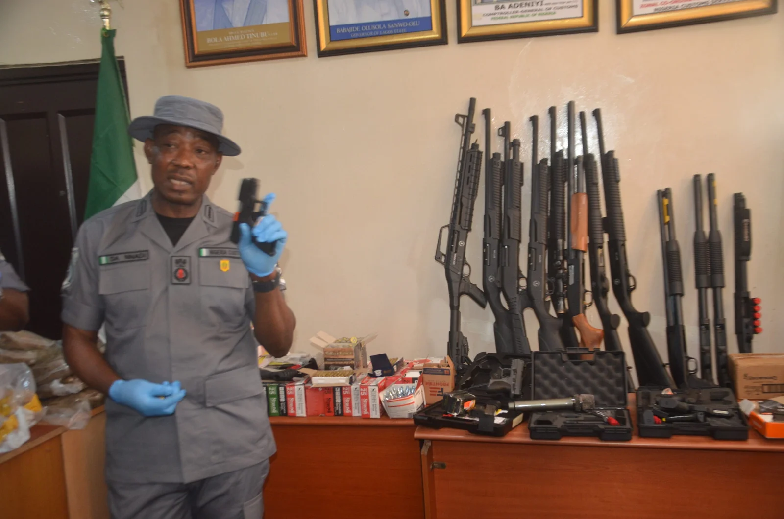 Customs Area Controller, Tin Can Island Port, Nigerian Customs Service, Comptroller Dera Nnadi display the intercepted Pistols and Riffles at the Tin Can Island Port before journalists, in Lagos, on Friday.