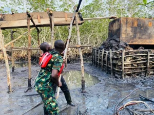 Nigeria Navy personnel destroying illegal oil refinery