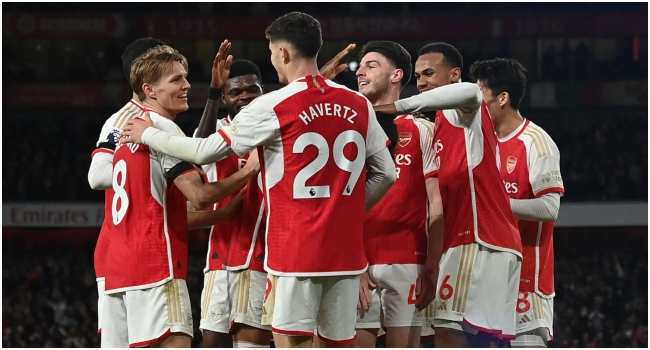 Arsenal’s English defender #04 Ben White celebrates with teammates after scoring their fifth goal during the English Premier League football match between Arsenal and Chelsea at the Emirates Stadium in London on April 23, 2024. (Photo by Glyn KIRK / AFP) /