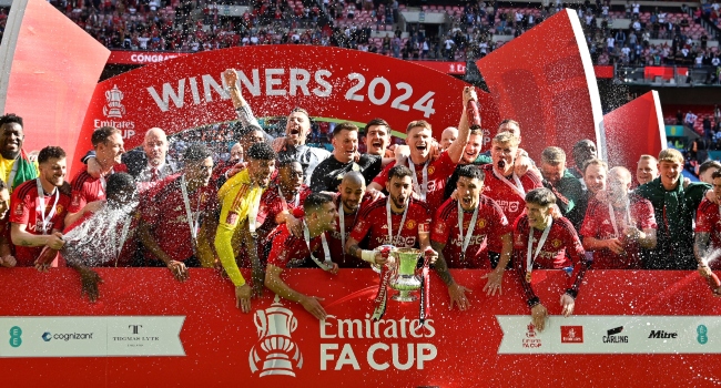Manchester United’s Portuguese midfielder #08 Bruno Fernandes lifts the trophy to celebrate their victory at the end of the English FA Cup final football match between Manchester City and Manchester United at Wembley stadium, in London, on May 25, 2024. Manchester United wins 2 – 1 against Manchester City. (Photo by Ben Stansall / AFP)