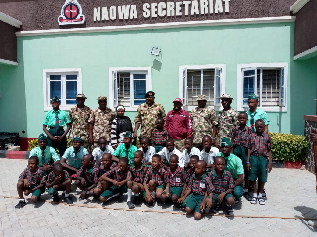 GOC 7 Division Nigerian Army, Brigadier General Haruna Ibrahim, in a group photograph with students and other dignitaries at an event to commemorate the 2024 International Day of the Boy Child which took place at NAOWA Secretariat Conference Hall, Maimalari Cantonment Maiduguri.
