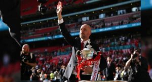 Manchester United’s Dutch manager Erik ten Hag holds the trophy as he waves to the fans to celebrate their victory at the end of the English FA Cup final football match between Manchester City and Manchester United at Wembley stadium, in London, on May 25, 2024. Manchester United wins 2 – 1 against Manchester City. (Photo by Ben Stansall / AFP)
