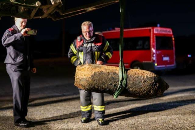 The defused bomb is transported ashore on a tractor, firefighters look at the World War II bomb and take photos. Following the discovery of a World War II bomb in the Rhine in Cologne-Langel, the unexploded bomb was defused on board a dredging vessel. Christoph Reichwein/dpa