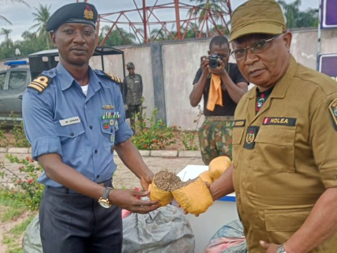 Lt.-Cdr Bitus Zoaka, the Base Operations Officer, Forward Operating Base, of Nigerian Navy, Badagry, representing the Commanding Officer , Navy Captain Augustus Amakiri handing over seized suspected cannabis sativa to Mr Ogbogoh Emmanuel, the Assistant Commander Narcotics, Sème Spécial Command, NDLEA, on Thursday.