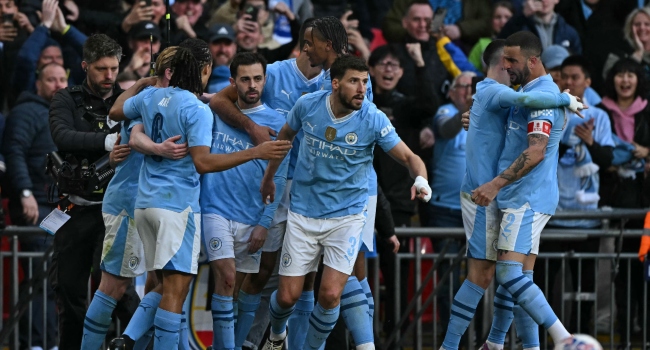 Manchester City’s Portuguese midfielder #20 Bernardo Silva (3L) celebrates with teammates after scoring the opening goal of the English FA Cup semi-final football match between Manchester City and Chelsea at Wembley Stadium in north west London on April 20, 2024. (Photo by Ben Stansall / AFP)