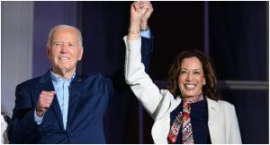 FILE: US President Joe Biden (L) and US Vice President Kamala Harris hold hands and gesture as they watch the Independence Day fireworks display from the Truman Balcony of the White House in Washington, DC, on July 4, 2024.