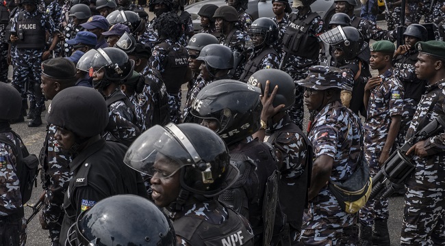 Police officers stand near the Lagos State Governors office as protesters march during a mourning vigil in Ikeja Lagos NigeriaEconomyPoliticsUnrest