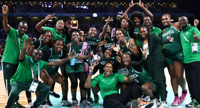 Nigeria’s players and staff, with Nigeria’s US coach Rena Wakama (3rdR) pose as they celebrate after winning the women’s preliminary round group B basketball match between Canada and Nigeria during the Paris 2024 Olympic Games at the Pierre-Mauroy stadium in Villeneuve-d’Ascq, northern France, on August 4, 2024. (Photo by Sameer AL-DOUMY / AFP)