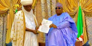 Alhaji Sama’ila Muhammadu-Mera, Emir of Argungu presenting a letter of conferment of traditional tittle from Sultan of Sokoto, Dr Sa’ad Abubakar to Gov. Nasir Idris of Kebbi on Friday in Birnin Kebbi.