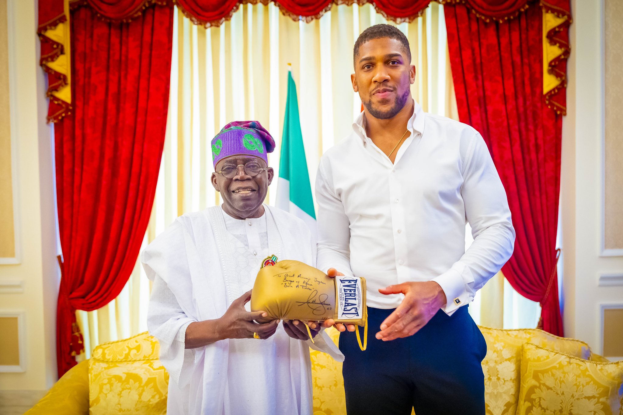 President Bola Tinubu receiving an autographed glove from former World Heavyweight Champion, Anthony Joshua, when he visited the President at his Ikoyi residence in Lagos. January 1, 2025