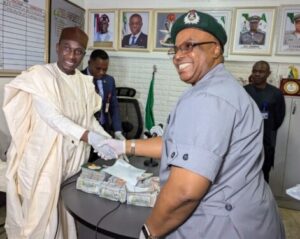 The Acting Director, Lagos office 2 of the EFCC, Mr Ahmed Ghali while receiving the suspect and the foreign currencies from the Controller in charge of Murtala Muhammed International (MMIA) Airport Command Comptroller Effiong Harrison at the MMIA Lagos on Friday.