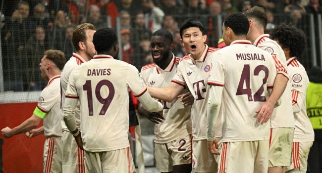Bayern Munich’s Canadian defender #19 Alphonso Davies (3rd L) celebrates after scoring the 0-2 goal with team mates during the EFA Champions League last 16, second leg, football match between Bayer Leverkusen and Bayern Munich in Leverkusen, western Germany on March 11, 2025. (Photo by INA FASSBENDER / AFP)