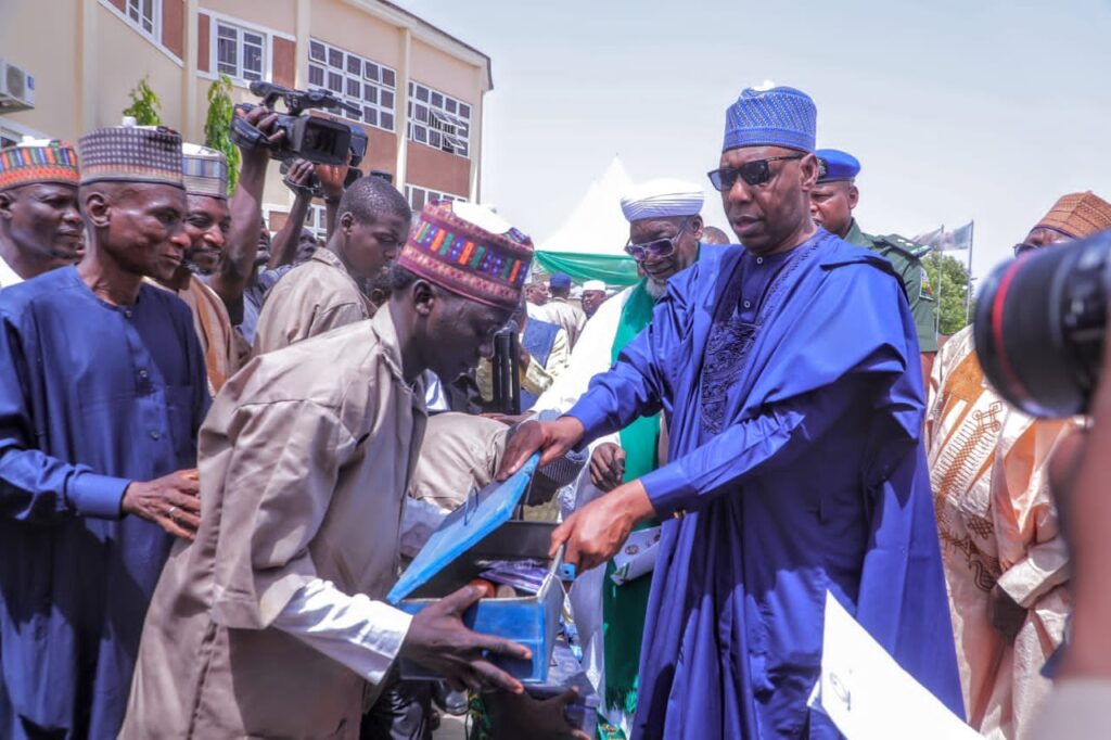 Borno State Governor, Babagana Zulum handling over working tools to one of the beneficiaries