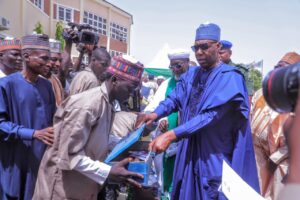 Borno State Governor, Babagana Zulum handling over working tools to one of the beneficiaries