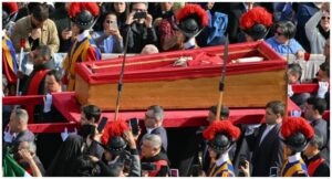 Pallbearers, next to Swiss Guards, carry the coffin of the late Pope Francis (C) as it is transported from the chapel of Santa Marta to St Peter’s Basilica, following the Pope’s death, in the Vatican on April 23, 2025. (Photo by Alberto PIZZOLI / AFP)
