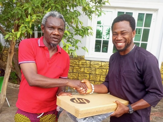 Rep. Chinedu Ogah presenting an HP computer system worth of ₦700,000 to the law student, Vincent Nwekoyo.