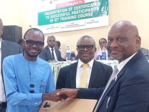 Pastor Uwem Andrew Essien (r), Accountant General of Akwa Ibom State presenting laptop computer to best graduating civil servant