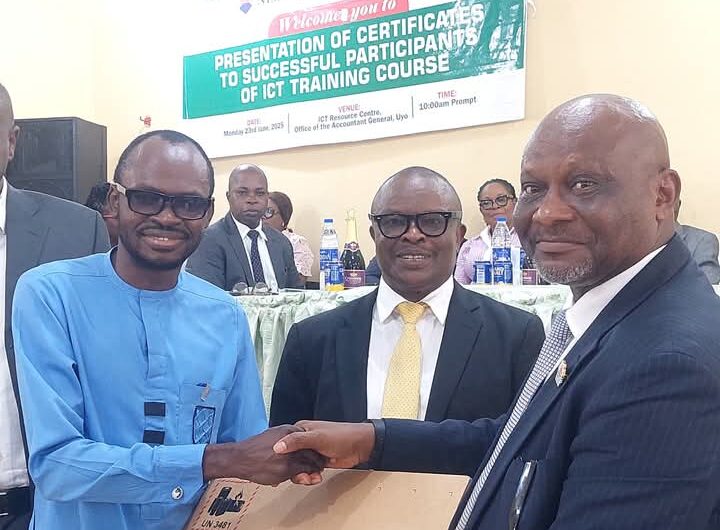 Pastor Uwem Andrew Essien (r), Accountant General of Akwa Ibom State presenting laptop computer to best graduating civil servant