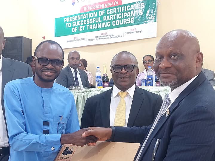 Pastor Uwem Andrew Essien (r), Accountant General of Akwa Ibom State presenting laptop computer to best graduating civil servant