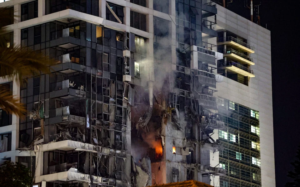 Fire and smoke rise from a building, reportedly hit by a missile fired from Iran, in central Tel Aviv Credit: JACK GUEZ/AFP