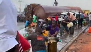 People scoop fuel from fallen petrol taner.jpeg