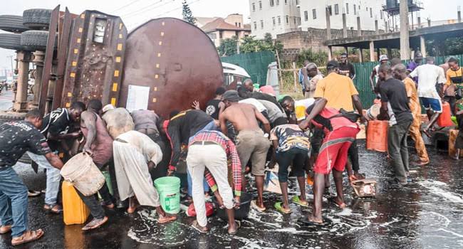 People scoop fuel from fallen petrol taner.jpeg
