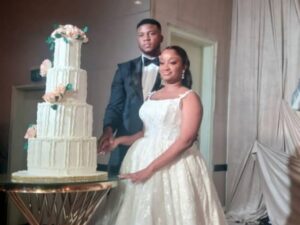Love on top! The happy couple–Tejiri and Damilola–stands tall with their beautiful wedding cake 🎂"