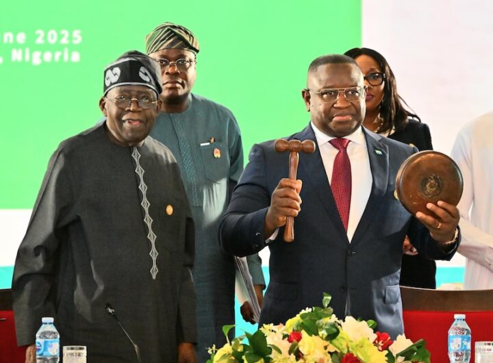 Nigerian President, Bola Tinubu handing and the new ECOWAS Chairman, Sierra Leone's President, Maada Bio