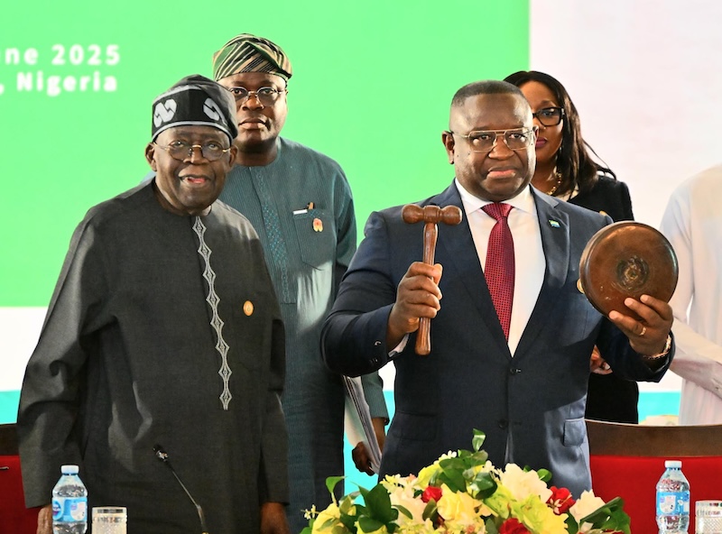 Nigerian President, Bola Tinubu handing and the new ECOWAS Chairman, Sierra Leone's President, Maada Bio