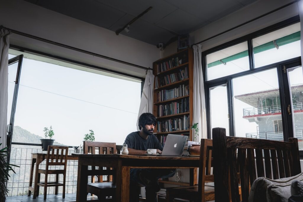 What Is AI Enablement? 2 A man sitting at a table with a laptop, focused on analyzing AI enablement performance indicators and ROI.