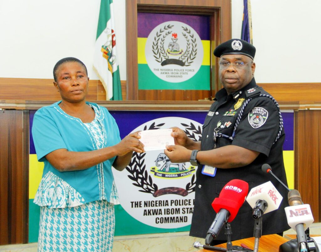 Baba Azare , Akwa Ibom CP presents a cheque to the bereaved family of an officer who died while in service