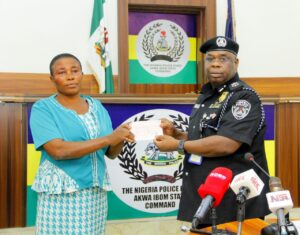 Baba Azare , Akwa Ibom CP presents a cheque to the bereaved family of an officer who died while in service
