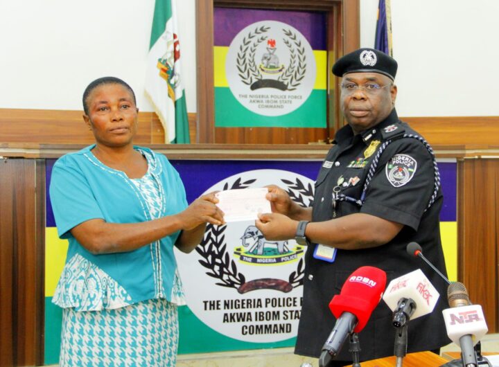 Baba Azare , Akwa Ibom CP presents a cheque to the bereaved family of an officer who died while in service