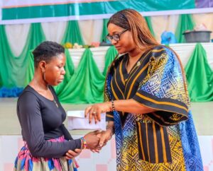 First Lady, Akwa Ibom State, Lady Helen Eno Obareki , presenting starter packs and cash to one of the beneficiaries
