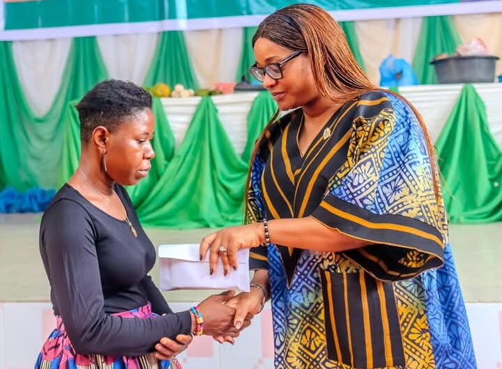 First Lady, Akwa Ibom State, Lady Helen Eno Obareki , presenting starter packs and cash to one of the beneficiaries
