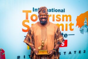 Kunle Afolayan displayimg his Tourism Entrepreneur of the Year Award during the Oyo international summit