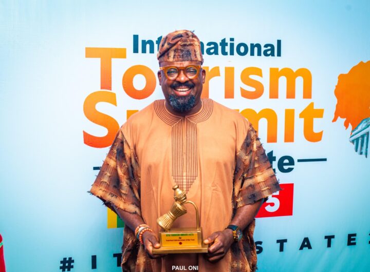 Kunle Afolayan displayimg his Tourism Entrepreneur of the Year Award during the Oyo international summit