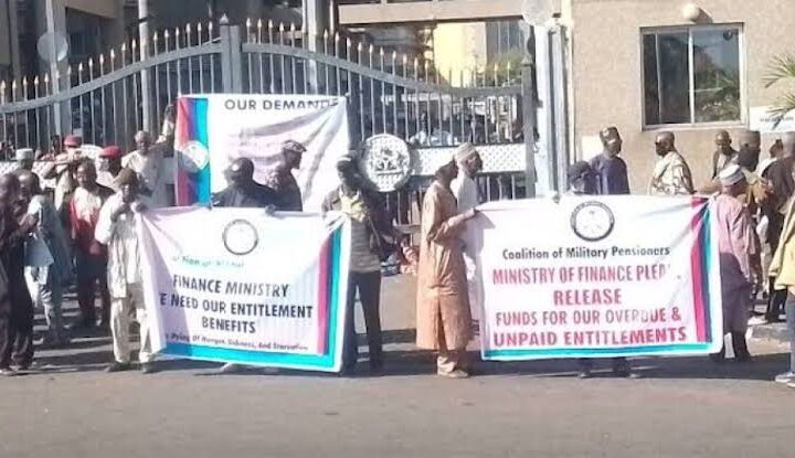 Retired soldiers barricade the entrance gate of the Ministry of Finance building in Abuja