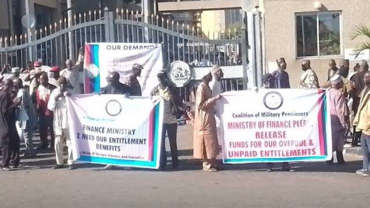 Retired soldiers barricade the entrance gate of the Ministry of Finance building in Abuja