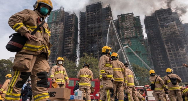 Firemen get ready after a major fire swept through several apartment blocks at the Wang Fuk Court residential estate in Hong Kong’s Tai Po district on November 27, 2025. DALE DE LA REY / AFP