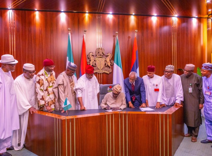 President Bola Tinubu (seated) signing the Electoral Act 2026 Into Signs Electoral Act 2026 Into Law