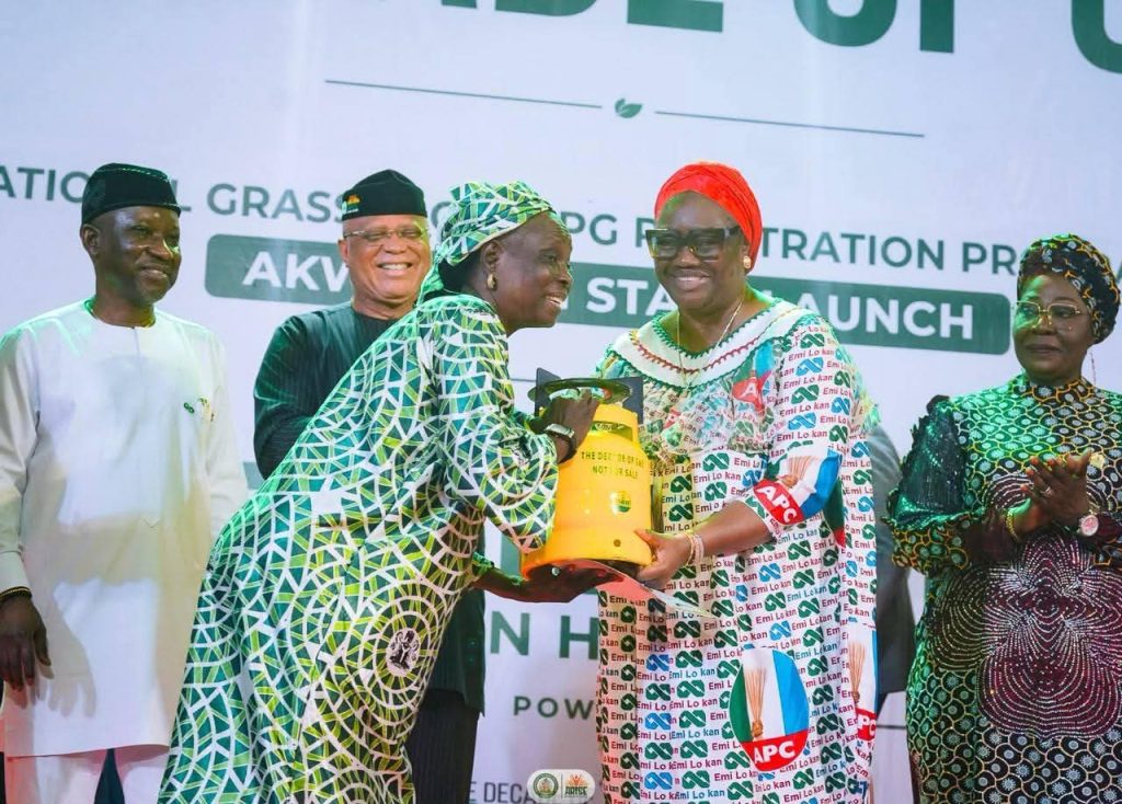 One of the beneficiaries receiving a gas cylinder from Ekaette Unoma Akpabio, wife of Senate President in the presence of Governor Umo Eno and Ekperikpe Ekpo, minister of Petroleum Resources (Gas) in Uyo, Akwa Ibom State